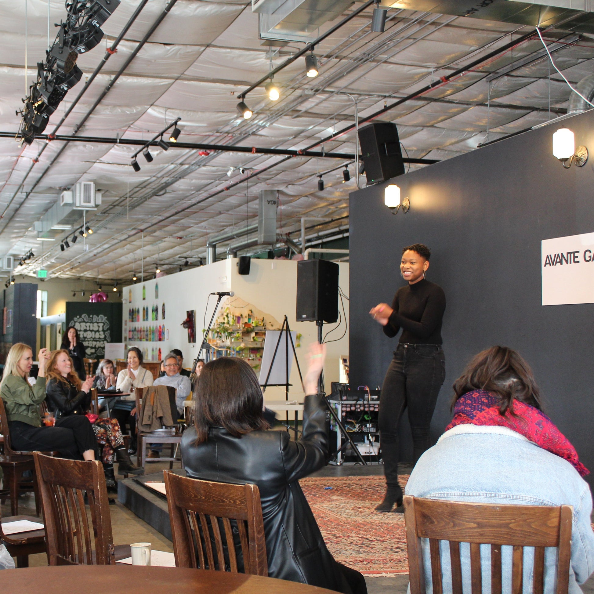 Art Event with a crowd of people seated and listening to a speaker on stage